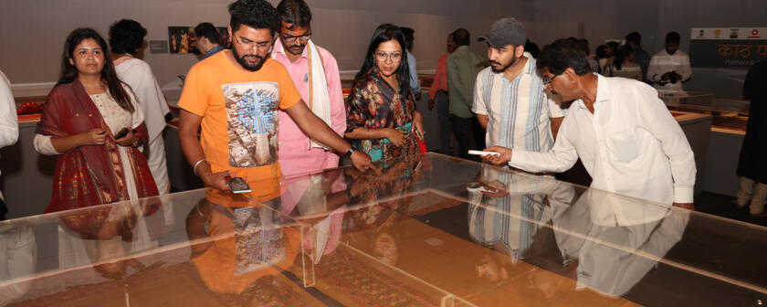 Visitors at the exhibition looking at the textiles